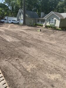 A dirt driveway in front of a house.