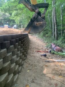 An excavator is working on a retaining wall.
