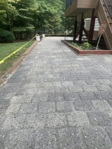 A brick paver walkway with a yellow tape on it.