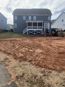 A dirt yard in front of a house.
